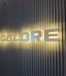 letra retroiluminada PVC led cálido sobre alistonado negro en detalle